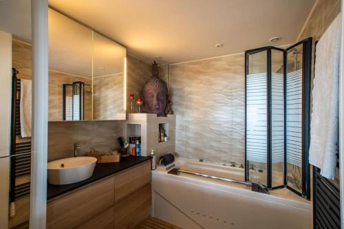 a bathroom with a sink and a bath tub at Suite vue sur mer in Marseille