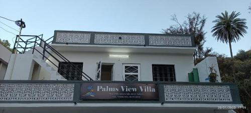 Palms View Villa في مونت ابو: البيت الأبيض مع وجود علامة أمامه