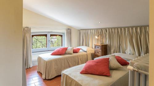 a bedroom with two beds and a window at VILLA IL CEDRO 10&1, Emma Villas in Sarteano