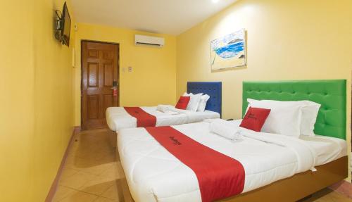 馬尼拉的住宿－RedDoorz at Comfy Inn Ermita Manila，黄色墙壁客房的两张床