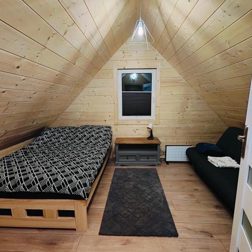 Habitación con cama y sofá en una cabaña en beskid.house1, en Spytkowice