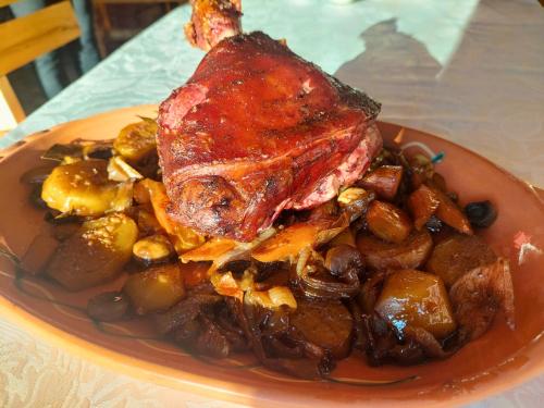 a plate of food with a piece of meat and vegetables at Villa Saturea in Boljevac