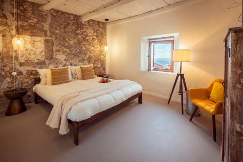 a bedroom with a bed and a window and a chair at Dea Little Suite in Palestrina