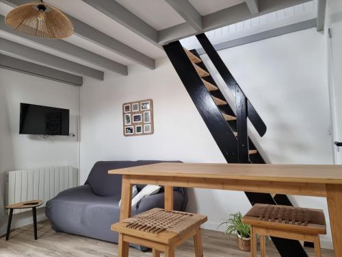 ein Wohnzimmer mit einem Tisch und einem blauen Sofa in der Unterkunft Studio cocooning au calme, proche centre-ville et centre commercial in Challans