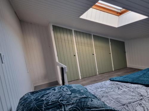 1 Schlafzimmer mit 2 Betten und einem Dachfenster in der Unterkunft Studio cocooning au calme, proche centre-ville et centre commercial in Challans