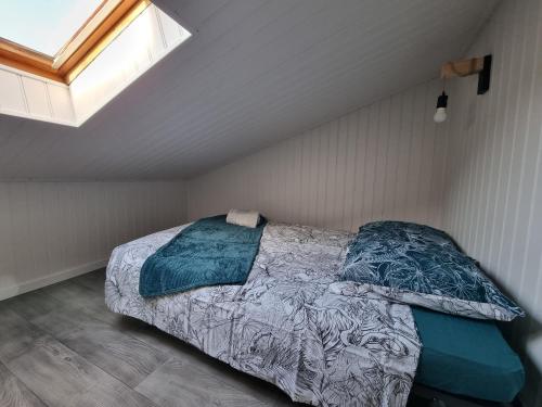 ein Schlafzimmer mit einem Bett im Dachgeschoss in der Unterkunft Studio cocooning au calme, proche centre-ville et centre commercial in Challans