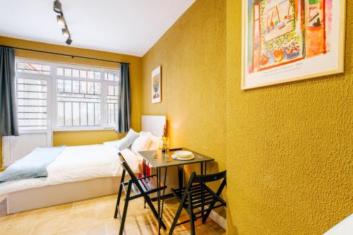 1 dormitorio con 1 cama y 1 mesa con sillas en Modern Suite w King Bed 20 min to Hagia Sophia, en Estambul