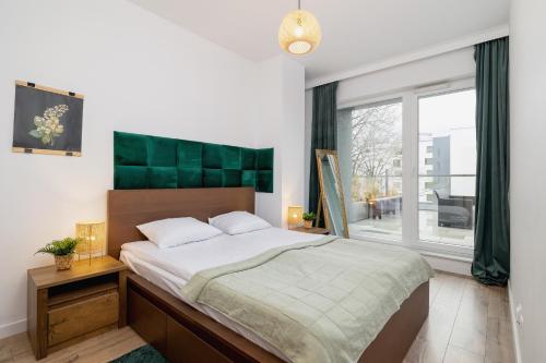a bedroom with a large bed and a large window at Exclusive Apartment in Katowice with Balcony, Parking, Gym and Sauna by Renters in Katowice