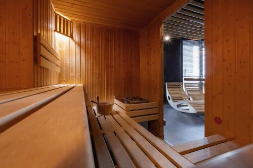a wooden sauna with a bench and a tub at Exclusive Apartment in Katowice with Balcony, Parking, Gym and Sauna by Renters in Katowice