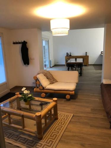 un salon avec un canapé et une table dans l'établissement Logement de plain-pied avec jardin, terrasse, à Gurgy