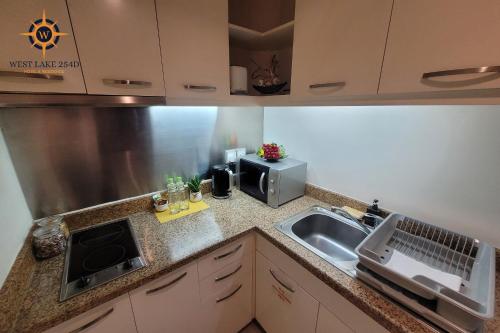 a kitchen with a sink and a microwave at West Lake 254D Hotel & Residence in Hanoi