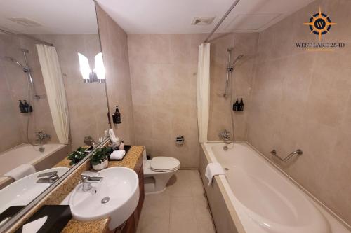 ein Badezimmer mit einem Waschbecken, einer Badewanne und einem WC in der Unterkunft West Lake 254D Hotel & Residence in Hanoi