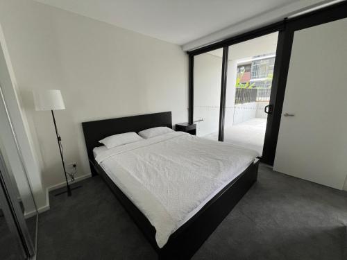 a bedroom with a bed and a large window at New modern 1BR apt near Dickson in Canberra