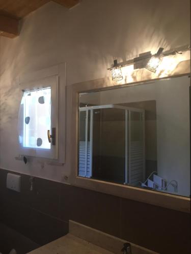 a bathroom mirror with a sink and a window at Aquila Di Mare in Fiumicino