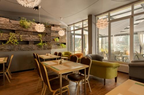 a restaurant with a table and chairs and windows at Płonia Resort in Szczecin