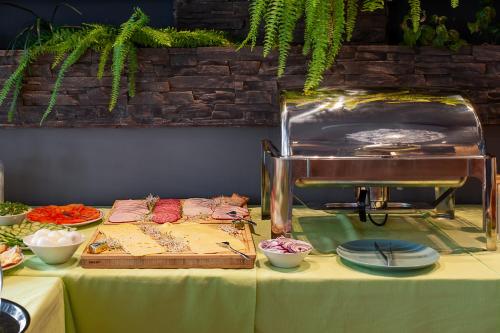 a table topped with plates of food and a grill at Płonia Resort in Szczecin