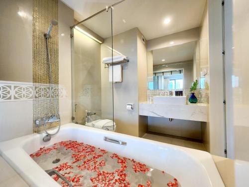 y baño con bañera, ducha y lavamanos. en FuramaXclusive Pratunam Park Hotel, en Bangkok