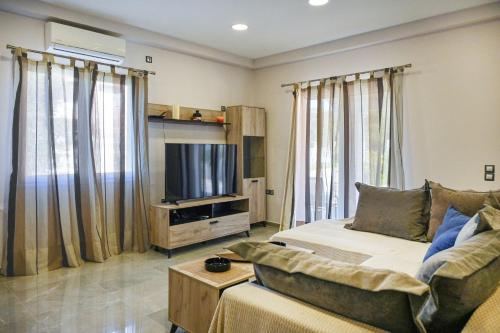 a living room with a couch and a flat screen tv at Villa Iskander in Roda