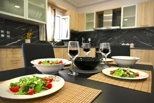 a table with two plates of food and glasses of wine at Villa Iskander in Roda