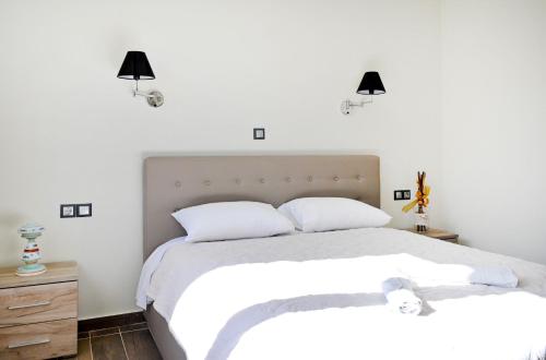 a bedroom with two white beds and two lamps at Villa Iskander in Roda