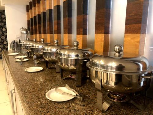 a row of silver pots lined up on a counter at Abdullah Residency in Srinagar