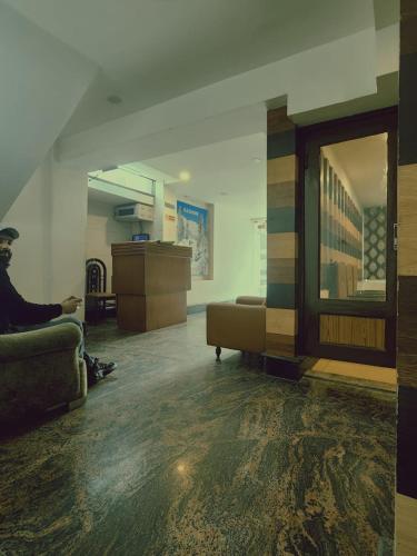 a man sitting on a couch in a living room at Abdullah Residency in Srinagar