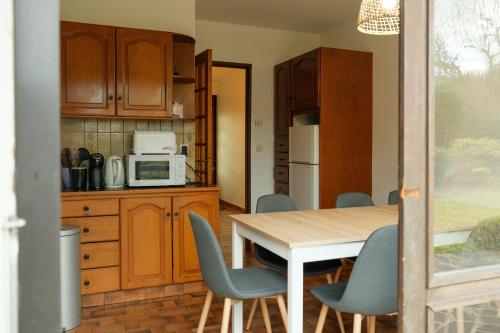 une cuisine avec une table et des chaises et un micro-ondes dans l'établissement Lovely house with garden, jardin et terrasse, à Seynod