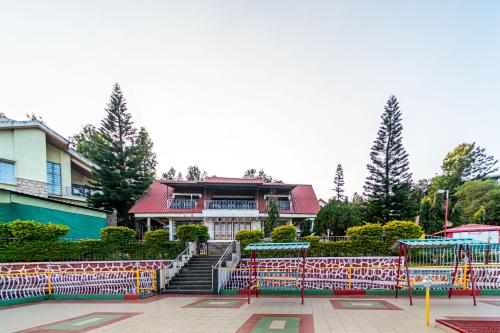 un edificio con una valla delante en Treebo Trend Raval Resort, en Panchgani