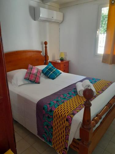 a bedroom with a bed with a wooden headboard at Maison créole chaleureuse avec stationnement in Le Gosier