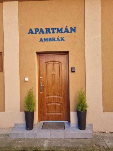 un edificio con una puerta de madera y dos macetas en Apartman Ambrak č.3, en Martin