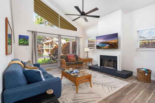a living room with a blue couch and a fireplace at Big Island Waikoloa Hills 1304 condo in Waikoloa Village