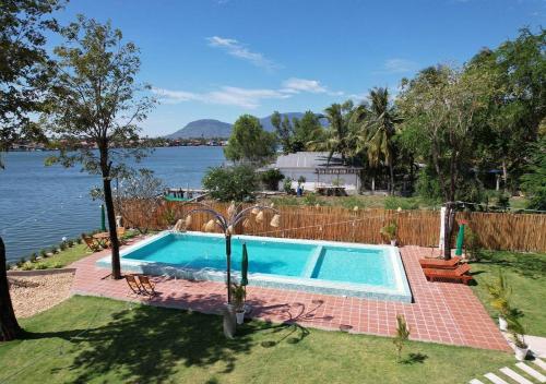 a swimming pool in a yard next to the water at SEA SAND RESORT in Kampot