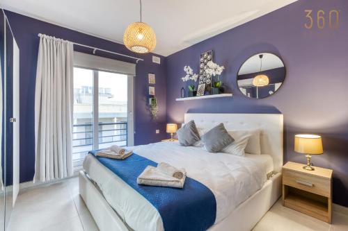 ein lila Schlafzimmer mit einem großen Bett und einem Spiegel in der Unterkunft LUX Duplex Penthouse w/ Expansive Rooftop Terrace by 360 Estates in San Ġwann