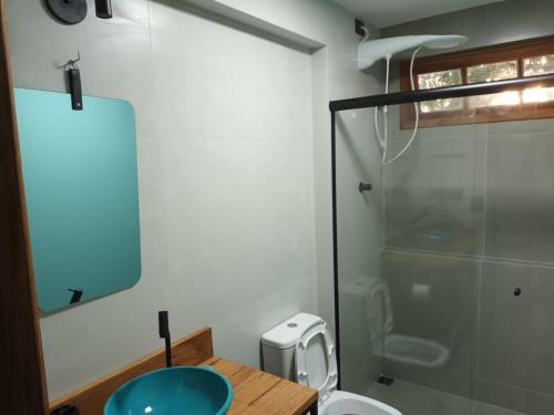 uma casa de banho com um WC e uma cabina de duche em vidro. em Bee My Guest em Búzios