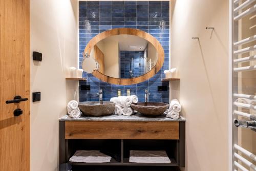 een badkamer met 2 wastafels en een spiegel bij Höflehner Premium Gumpen Lodge in Haus im Ennstal
