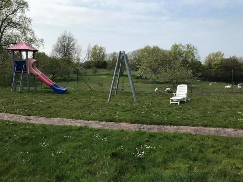 a playground with a slide and a chair in a field at Fehmarn 17-4 in Fehmarn