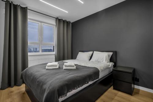 a bedroom with a bed with two towels on it at 12th Floor Wola Modern Apartment in Warsaw