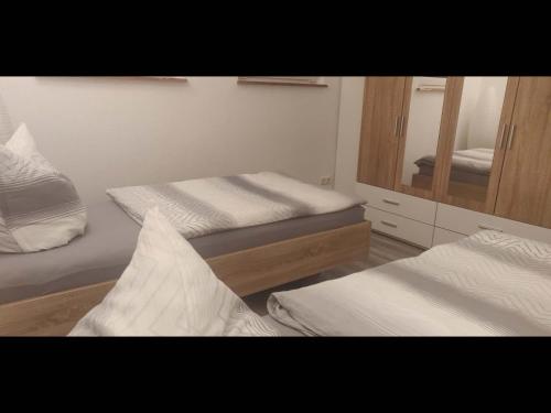 a bedroom with two beds and a mirror at NEU! Spreewald-FeWo mit Pool in Vetschau