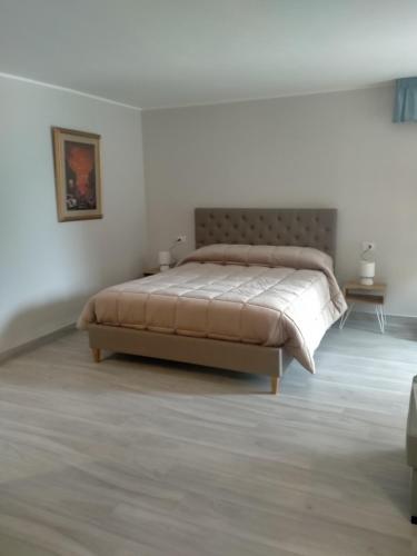 een slaapkamer met een bed in een witte kamer bij casa tizziani in Caserta