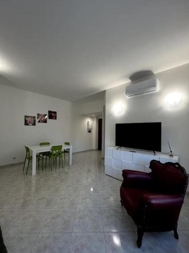 sala de estar con sofá, TV y mesa en Le case di Edo, en Latina