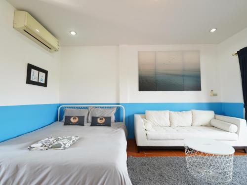 sala de estar con 2 camas y sofá en RoomQuest One Bangsaray en Bang Sare