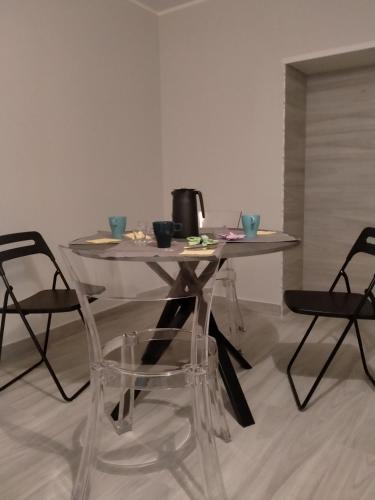 una mesa de cristal y sillas en una habitación en casa tizziani, en Caserta