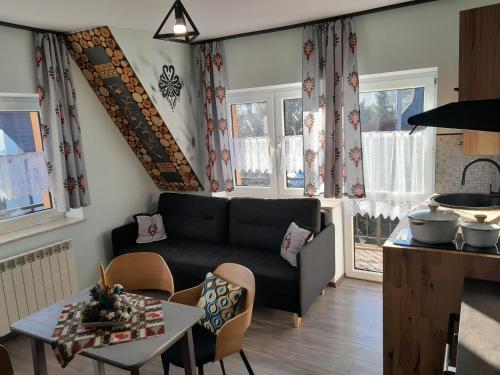 a living room with a couch and a table at Apartamenty Wierch 17 in Kościelisko