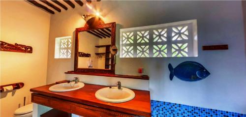 a bathroom with two sinks and a mirror and a fish on the wall at Fully Private 390sqm VILLA 3stars NO SHARING serviced Matemwe beach in Gazija