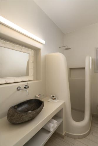 a bathroom with a stone sink on a counter at White Dunes Luxury Boutique Hotel in Santa Maria