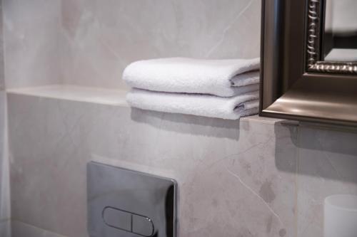 une pile de serviettes assises sur un comptoir à côté d'un miroir dans l'établissement AN Hotel, à Šiauliai