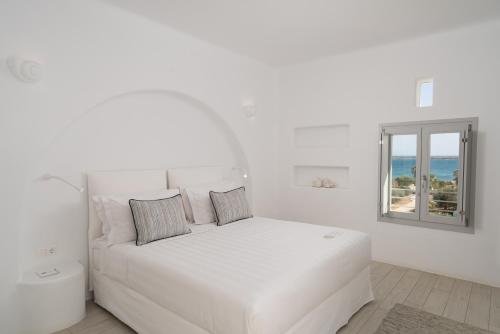 a white bedroom with a white bed and a window at White Dunes Luxury Boutique Hotel in Santa Maria