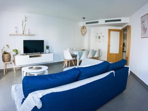 a living room with a blue couch and a tv at Habitaciones privadas con baño en piso céntrico Gandía in Gandía