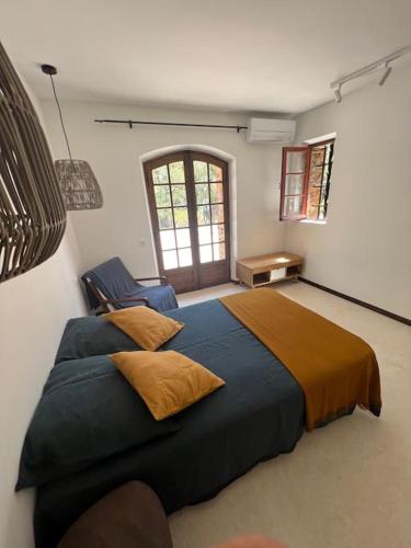 une chambre avec un grand lit et une chaise dans l'établissement Villa au cœur du massif des Maures, à La Garde-Freinet