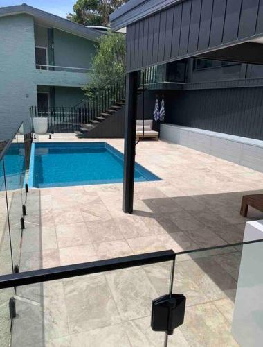 a swimming pool in front of a house at Shed. Holiday Apartment in Nelson Bay